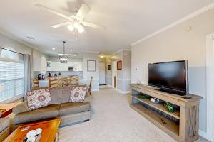 a living room with a couch and a flat screen tv at Cypress Bay 14-204 in Little River