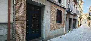 un edificio de ladrillo con una puerta negra en una calle en Bonito piso en San Ildefonso - Centro, en Jaén
