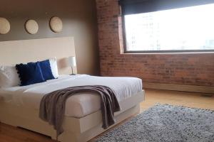 a bedroom with a bed and a brick wall at 1600 KCM Penthouse Apartment in Cleveland