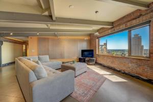 a living room with two couches and a large window at 1600 KCM Penthouse Apartment in Cleveland