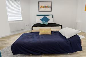two beds in a room with a blue blanket at Exeter City Centre Apartments Stoop Apartment in Exeter