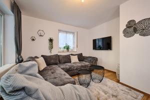 - un salon avec un canapé et une table dans l'établissement apanoxa homes I zentral I Parkplätze I Deluxe Apartment, à Straubing