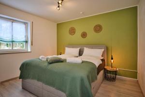 a bedroom with a bed with a green wall at apanoxa homes I zentral I Parkplätze I Deluxe Apartment in Straubing