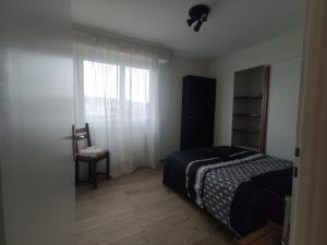 ein Schlafzimmer mit einem Bett, einem Stuhl und einem Fenster in der Unterkunft City Break - 7 pers Tramway GVA in Annemasse