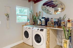 uma lavandaria com uma máquina de lavar roupa e um espelho em Solstice Oasis em Fort Lauderdale