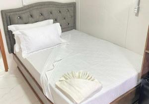 uma cama com lençóis brancos e almofadas brancas em Pousada São Miguel Beach Beira Mar em Penha