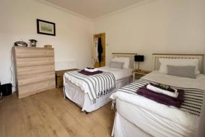 um quarto com 2 camas e uma cómoda em “TAWAW” A Lux 2BD Bungalow Harton South Shield em South Shields