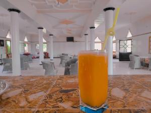 a glass of orange juice sitting on a table at La belle vue Elmazini in Demnat