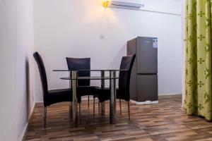 a table and chairs in a room with a refrigerator at E&T Resorts in Buea