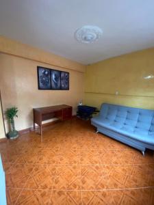 un soggiorno con divano blu e tavolo di Hostel Kumho Home a Medellín