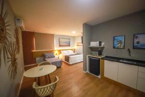 a hotel room with a bed and a table at O Azul de Maragogi - Pousada Premium in Maragogi