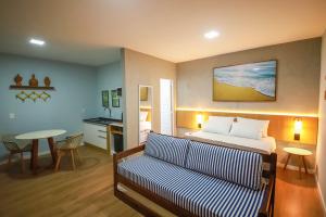 um quarto de hotel com uma cama e um sofá em O Azul de Maragogi - Pousada Premium em Maragogi