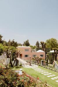 a large pink house with a fountain in the yard at La Posada del Puente in Arequipa