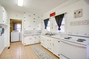 a kitchen with white cabinets and a white refrigerator at Historic Farnam Home Near Three Brothers Vineyard! 