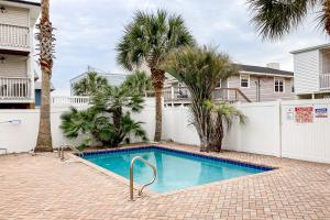 una piscina con palmeras y una valla blanca en Seahorse Serenity, en Myrtle Beach