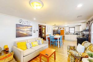 a living room with a couch and a kitchen at Seahorse Serenity in Myrtle Beach