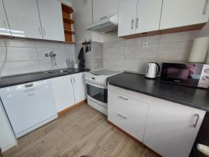 a kitchen with white cabinets and a black counter top at Odpocznij w Lesku in Lesko