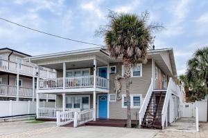 a house with a palm tree in front of it at Seahorse Serenity in Myrtle Beach