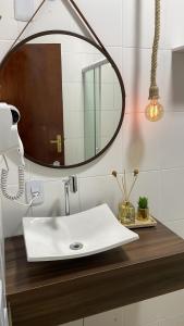 y baño con lavabo blanco y espejo. en Chalé das Águas, en Igaratá