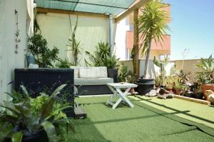 a patio with a couch and a table and plants at Ria Terrace Apartment III in Faro