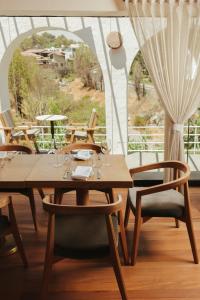 a wooden table and chairs in a room with a window at La Posada del Puente in Arequipa
