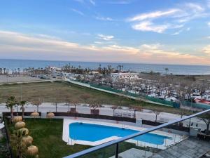 a view of a resort with a pool and the ocean at Golden view costa del sol in Torre del Mar