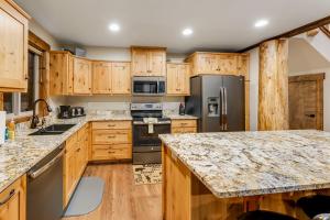 una cocina con armarios de madera y electrodomésticos de acero inoxidable en Experience Montana Cabins - Lake View Luxury Cabin #7 en Bigfork