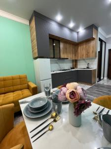 una cocina con una mesa con platos y flores. en Рахат апарт en Aktobe