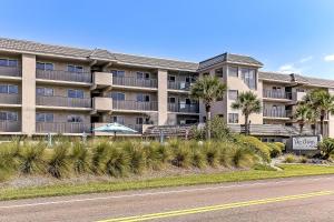 an apartment building with palm trees in front of a road at 112 Oceans Of Amelia in Amelia Island