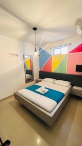 a bedroom with a bed with a colorful wall at Kromatic Hostel in Medellín