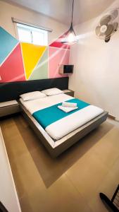 a bed in a room with a colorful wall at Kromatic Hostel in Medellín