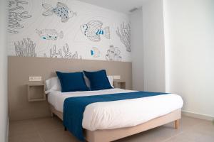1 dormitorio con 1 cama con sábanas azules y blancas en Apartamentos Barlovento, en Puerto de Mazarrón