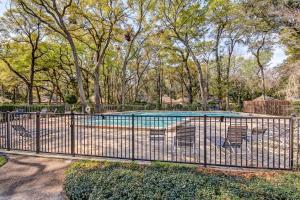 a fence with chairs in front of a swimming pool at 3325 Fairway Oaks in Amelia Island