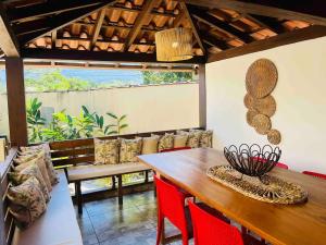 a dining room with a wooden table and red chairs at Pousada Naus de Paraty in Paraty