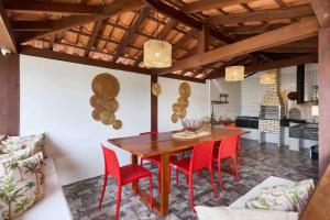uma sala de jantar com uma mesa de madeira e cadeiras vermelhas em Pousada Naus de Paraty em Paraty