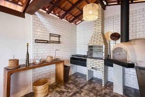 a large kitchen with a pizza oven in it at Pousada Naus de Paraty in Paraty