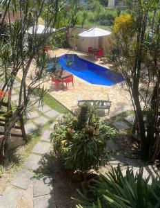 una piscina en un patio con sillas y mesa en Pousada Naus de Paraty, en Paraty