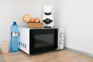 a microwave oven with bread and a bottle of water at Apartamentos Barlovento in Puerto de Mazarrón
