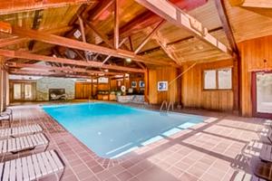 einen großen Pool in einem Zimmer mit Holzdecken in der Unterkunft Piper Ridge in Forest Farms