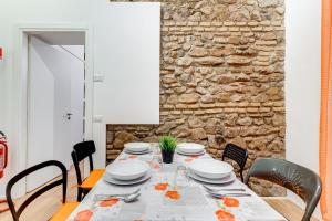 a dining room with a table with chairs and a stone wall at TRASTEVERE SUITE EXPERIENCE in Rome