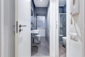 a white bathroom with a toilet and a sink at TRASTEVERE SUITE EXPERIENCE in Rome