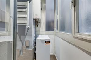 a bathroom with a white refrigerator and a window at TRASTEVERE SUITE EXPERIENCE in Rome