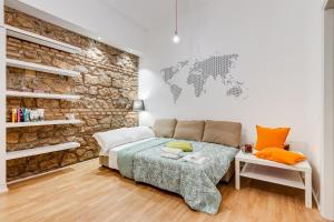 a bedroom with a bed and a brick wall at TRASTEVERE SUITE EXPERIENCE in Rome