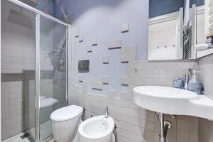 a white bathroom with a sink and a toilet at TRASTEVERE SUITE EXPERIENCE in Rome