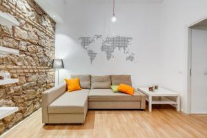 a living room with a couch and a stone wall at TRASTEVERE SUITE EXPERIENCE in Rome