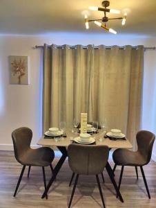 2 bedroom en-suite apartment in Basildon, Essex (Enjoy the simple things in life) في Laindon: طاولة طعام مع كراسي وغرفة طعام
