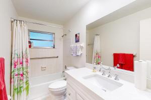 ein weißes Bad mit einem Waschbecken und einem WC in der Unterkunft East Side Escape in Sarasota