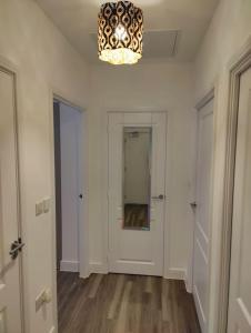 an empty room with a chandelier and a hallway at 2 bedroom en-suite apartment in Basildon, Essex (Enjoy the simple things in life) in Laindon