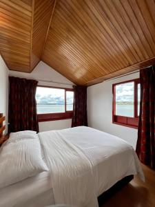 阿基塔尼亞的住宿－Hotel Refugio Santa Ines，一间卧室设有一张大床和两个窗户。