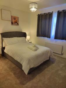 2 bedroom en-suite apartment in Basildon, Essex (Enjoy the simple things in life) في Laindon: غرفة نوم بسرير كبير في غرفة
